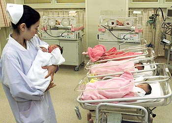 ممرضة يابانية تحمل طفلا في مركز الأمومة والطفولة بمستشفىجامعة جيكي في طوكيو