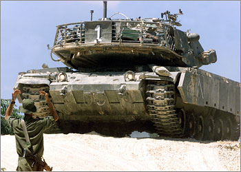 An Israeli soldier guides a Merkava tank on the outskirts of Bethlehem June 23, 2002. More than 12 Merkava tanks, several Armored Personnel Carriers (APC's), other military vehicles and army soldiers took up positions on the outskirts of Bethlehem, blocking the area to civilian traffic. As Israeli armour rumbled into another Palestinian city on Sunday the army said it was calling up a brigade of reservists under emergency mobilization orders as part of what it was described as a war against terrorism. REUTERS/Yannis Behrakis