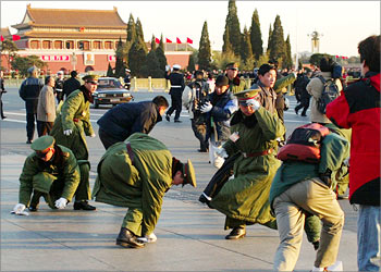 Chinese policemen pick up protest leaflets thrown by two demonstrators outside the Great Hall of the People before the start of the 16th Chinese Communist Party Congress at the Great Hall of the People in Beijing November 8, 2002. China kicked off a major meeting of the ruling Communist Party on Friday, an event expected to enact a sweeping leadership change including the retirement of party chief and president Jiang Zemin. REUTERS/Bobby Yip