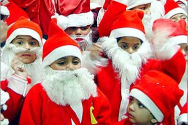 Indian children dress as Santa Claus during a gathering