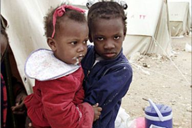 r - A young Sudanese girl carries her sister at a refugee camp managed by the Red Cross and the Red Crescent, about 60 km