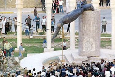 Iraqis watch a statue of Iraqi President Saddam Hussein falling in Baghdad's al-Fardous (paradise)