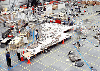 This photo shows a high angle view in Kennedy Space Center's RLV Hangar 15 May 2003 with the layout of the left wing area with the white stand (C) being used to place thermal wing tiles. With about 38 percent by weight of the space shuttle Columbia debris shipped to Florida, the Reconstruction Team is attempting to reconstruct the bottom of the orbiter as part of the investigation. AFP PHOTO/ NASA