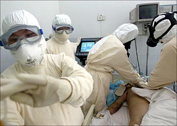Chinese doctors and nurses wear protective suits as they tend to a SARS patient at a hospital in Beijing May 1, 2003. China kicked off a campaign to raise money to buy better protective equipment for medical workers and support their work in the fight against SARS. China said on Thursday 11 more people had died from Severe Acute Respiratory Syndrome (SARS) and another 187 were infected, taking the death toll to 170 and the number of cases to 3,647. REUTERS/China Photo