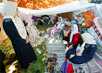 R_Algerian women sit in their hand-made shelter in the Algerian town of Boumerdes May 24, 2003 after their homes were damaged in the earthquake which hit Algeria's Mediterranean coast three days ago. Hopes dwindled on Saturday of finding survivors three days after the worst earthquake in Algeria for more than two decades, which killed more than 1,750 people. REUTERS/Yves Herman