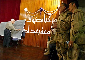 afp - BAGHDAD IRAQ : US soldiers look on as a clerk writes candidates names on a board during faculty elections at Baghdad University, the biggest in Iraq, 17 May 2003. Over 900 members will elect a new administration to replace the one dating from the days of Saddam Hussein's regime. According to US appointed officials, the new administration will be elected following criteria of competence and without discrimination to those who were minor members of the ex-ruling Baath party