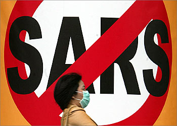 A masked Taiwanese woman strolls past a huge anti-SARS sign at a shopping mall in Taipei, May 27, 2003. Taiwan, which has the world's third-worst outbreak of Severe Acute Respiratory Syndrome (SARS), says the disease is under control as the island reported 11 new probable cases on Tuesday, taking the total to 596. REUTERS/Richard Chung