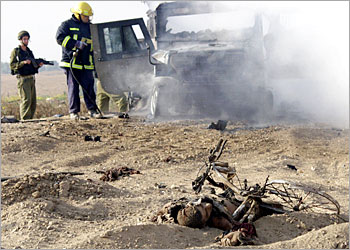 The body of a Palestinian suicide bomber lies next to his bicycle as Israeli fireman extinguish the fire which ripped through an army Jeep following the attack near the Kfar Darom Jewish settlement in the southern Gaza Strip 19 May 2003. Three Israeli soldiers were slightly injured when a Palestinian suicide bomber riding a bike detonated his explosives as they passed in a jeep in the area early in the morning. AFP PHOTO/Moti SENDER