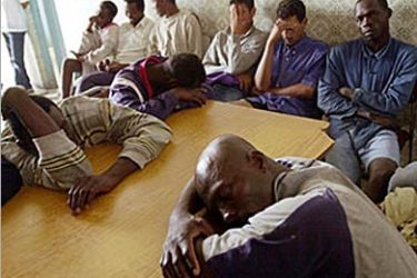 afp - Clandestine immigrants, including nationals of Mali, Ghana, Somalia, Egypt and Morocco, who survived when their boat capsized off the coast of Libya one day earlier, wait 21 June 2003 at the Tunisian national guard premises in Sfax