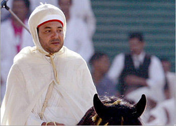 f: King Mohammed VI of Morocco greets the crowds as he rides a horse in Tetouan during the 4th anniversary celebrations of his accession to the throne, 31 July 2003.