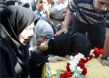 The mother and sisters of Hezbollah activist Ammar Hammoud weep over his coffin during his funeral following the repatriation of two bodies of Lebanese Shiite Muslim Hezbollah fighters by Israel 25 August 2003 in the Lebanese southern port of Naqoura, near the border with Israel. The bodies were transported in two Lebanese Red Cross ambulances preceded by an International Committee for the Red Cross (ICRC) vehicle, past the Lebanese army checkpoint, to the first Hezbollah position at the seafront road near the border.