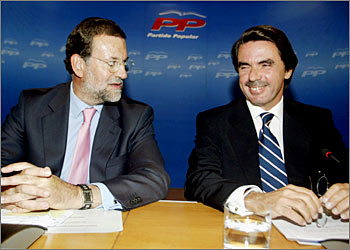 Spanish Prime Minister Jose Maria Aznar (L) and his Deputy PM Mariano Rajoy smile during their ruling Popular Party (PP) National Executive Committe meeting at Party's headquarters September 1, 2003. Rajoy is to get his reward for years of faithfull service by being named as heir to Aznar for the next year's general elections.REUTERS/Sergio Perez