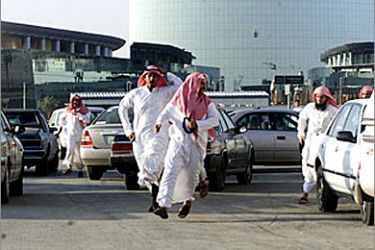 F_Saudi men flee from police during a protest in the capital Riyadh 14 October 2003.