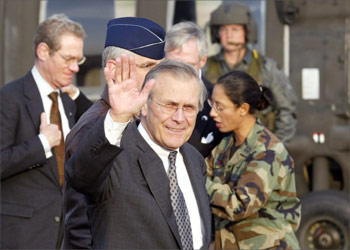 US Defense Secretary Donald Rumsfeld (3rd L) waves to journalists upon his arrival at the US Forces' Yokota Air Base in Tokyo 15 November 2003. Rumsfeld arrived here by UA-60 helicopter from Yokosuka Naval Base