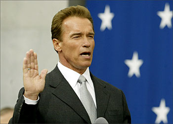 R_Arnold Schwarzenegger (C) is sworn in as California's 38th Governor by California Chief Justice Ronald George during a ceremony at the State Capitol in Sacramento, November 17, 2003. REUTERS/Gary Hershorn