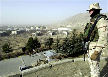F_An unidentified American soldier from the US led coalition force stands guard by the Intercontinental Hotel in Kabul overlooking the large white tent where 500 Afghan delegates will meet in a Loya Jirga to debate and ratify the country's new draft constitution, 13 December 2003. Security is tight, with US troops, international peacekeepers, Afghan national army soldiers, police and secret service agents providing a ring of steel around the site. Approval of the constitution will pave the way for Afghanistan's first democratic elections, scheduled to take place in June 2004. AFP PHOTO/ SHAH Marai