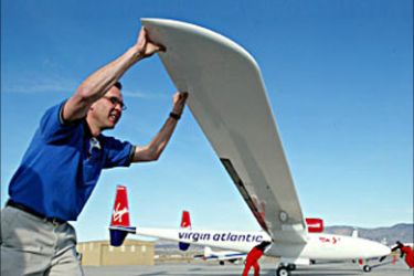 r / Ground crew push the Virgin Atlantic GlobalFlyer out of its