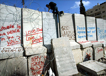 F_A Palestinian schoolboy climbs over the concrete blocks that separates in two the West Bank village of Abu Dis on the edge of Jerusalem 12 February 2004. The European Union yesterday condemned Israel's construction of a security barrier on the West Bank but restated its opposition to a UN challenge to the wall at the World Court in The Hague. AFP PHOTO/MENAHEM KAHANA