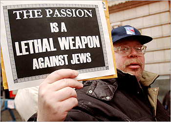 A protester displays a sign handed out to about three dozen Jewish demonstrators gathered in front of a Times Square movie theater to protest the depiction of Jews in the Mel Gibson film The Passion of the Christ, in New York on February 24, 2004, a movie which they have not seen. The movie, which opens tomorrow, has drawn both praise and criticism from religious groups. REUTERS/Chip East