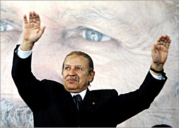 Abdelaziz Bouteflika, Algerian President and candidate in the upcoming Algerian presidential elections, waves to his supporters in front of his giant portrait during a pre-election campaign meeting in the western city of Chlef March 25, 2004. The presidential elections are scheduled for April 8, 2004. REUTERS/Zohra Bensemra