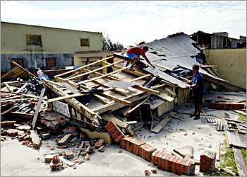 Residents start to clean up their home in Torres, March 29, 2004, after a rare cyclone that formed in the South Atlantic came ashore in southern Brazil and destroyed buildings on March 28, 2004. A rare cyclone that brought hurricane-like winds to southern Brazil killed at least two people, injured about 80 and forced some 30,000 people to leave their homes, the authorities said on Sunday. REUTERS/Paulo Whitaker