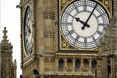 Two anti-war demonstrators are perched (L) just below the clock on the face of Big Ben in London's Parliament Square
