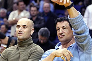 R/U.S. actor Sylvester Stallone (R) pretends to shoot a basket as he watches warm-ups with tennis star Andre Agassi