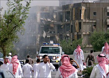 Saudis gather in front of the partially destroyed headquarters building of the general security services in Riyadh, following a car bomb explosion 21 April 2004. The car bomb in the heart of the Saudi capital killed and wounded many people, an AFP correspondent reported. Thick smoke poured from the front of the seven-storey building, which is part of the security headquarters in Riyadh's Al-Washm district