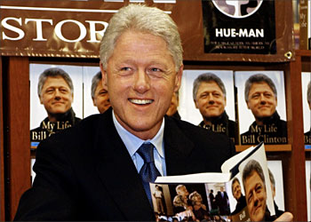 F_Former US president Bill Clinton poses with a copy of his new book, "My Life" during an autograph session, 22 June, 2004, at the Hue-Man bookstore in the Harlem section of New York Ctiy. AFP PHOTO/Stan HONDA