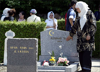 F_A woman mourns beside one of more than 50 Muslim graves which were painted with Neo-Nazi slogans and swastikas over the week-end, 15 June 2004 at the Meinau cemetery in the French eastern city of Strasbourg. A Muslim cemetery and a village in eastern France were vandalised Sunday night, prompting French Interior Minister Dominique de Villepin to head to the region 14 June to speak with officials and religious representatives. AFP PHOTO OLIVIER MORIN
