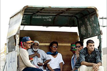 f / Foreign workers sit in the back of a truck as they are driven to work in Riyadh 14 July 2004. Foreign workers in Saudi Arabia are systematically abused and exploited, some of them living in