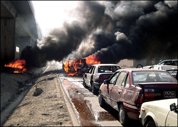 afp/Flames rise from two burning cars at site of an attack targeting a convoy for the Iraqi Minister of Justice, Malek Dohan al-Hassan 17 July 2004 in Baghdad. A powerful bomb exploded early today in the path of a convoy for Malek Dohan al-Hassan killing at least two of his bodyguards. The cause of the blast was attributed to a suicide car bomber by some people on the scene but others said it was a powerful roadside device targeting the convoy. AFP PHOTO/Ahmed FADAAM