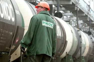 r: An employee of embattled Russian oil company Yukos oversees the loading of rail tanker cars to be sent to China from Angarsk 70 km from the Siberian city of Irkutsk, August 27,