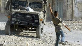A Palestinian child throws stones to an Israeli army vehicle during a military operation in Balata refugee camp in the West Bank city of Nablus, 27