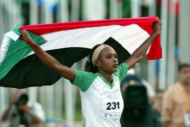 Sudanese Muna Adam waves her national flag after finishing first during the 400m women final at the 10th Arab Games in Algiers 05 October 2004