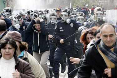 AFP - Demonstrators run away from riot policemen during a demonstration ahead of 08 March International Women's