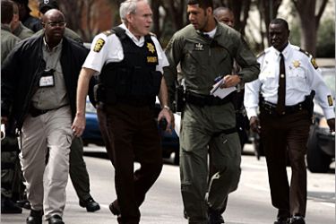 Police and crime investigators walk outside the Fulton County courthouse after a shooting inside the courthouse in Atlanta, March 11, 2005. Three people were killed including a judge, a sheriff's deputy and a court clerk and another deputy is in critical condition. REUTERS/Tami Chappell