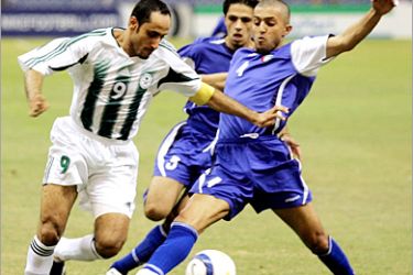 Saudi Arabia's Sami Aljaber (L) dribbles past two Kuwait defender, Ali Asel (R) and Nohayr Al Shammari, during their Group A World Cup qualifying match in Riyadh June 3, 2005. REUTERS/Zainal Abd Halim