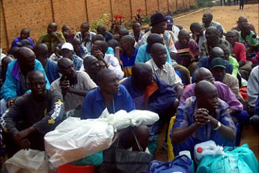 r_Rwandan prisoners, some of whom were accused for the 1994 genocide wait with their belongings outside the Kigali central prison in the capital Kigali July