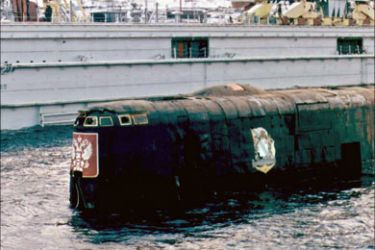 r - The conning-tower of the Kursk nuclear submarine surfaces in a dock of Roslyakovo port near Murmansk in this October 23, 2001 file photo