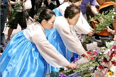 AFP - Korean women place flower bouquets at a memorial monument for Korean A-bomb victims, during a memorial service at the Hiroshima's Peace Memorial Park 05 August