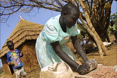 f_A young South Sudanese woman is seen preparing a daytime meal 03 August 2005 in a village