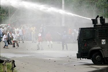 f_Protesters throw stones at a water cannon 19 August, 2005 in Lago Agrio, province of Sucumbios,