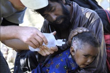 afp - An US nurse from "Save the Children" non-governmental organisation treats a Pakistani baby injured in the last earthquake in Pashto area in the mountains in the