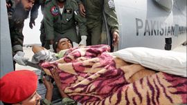 r_An injured Kashmiri earthquake survivor is moved into a Pakistan navy plane to be shifted