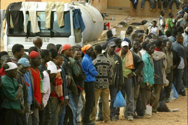 afp - Immigrants from Mali cue 09 October 2005 in the wait to be transfered to Udja, north of Morroco, to board a plane that will take them to Mali, after spending