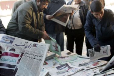 Iraqis read the headlines of newspapers one day after the announcement of Iraq's December general elections results in Baghdad 21 January 2006