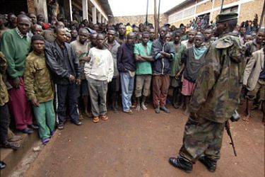 f_A Burundian soldier (R) stands next to a crowd of prisoners gathered to listen to the speech of