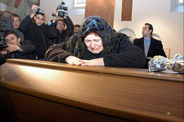 f_A catholic woman cries atop the coffin of 60 year old Italian Catholic priest Andrea Santoro 06 February