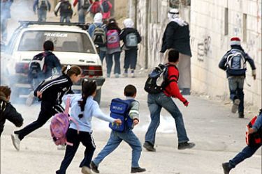 r_Palestinian school children run after an Israeli tear-gas canister during a protest against a controversial Israeli